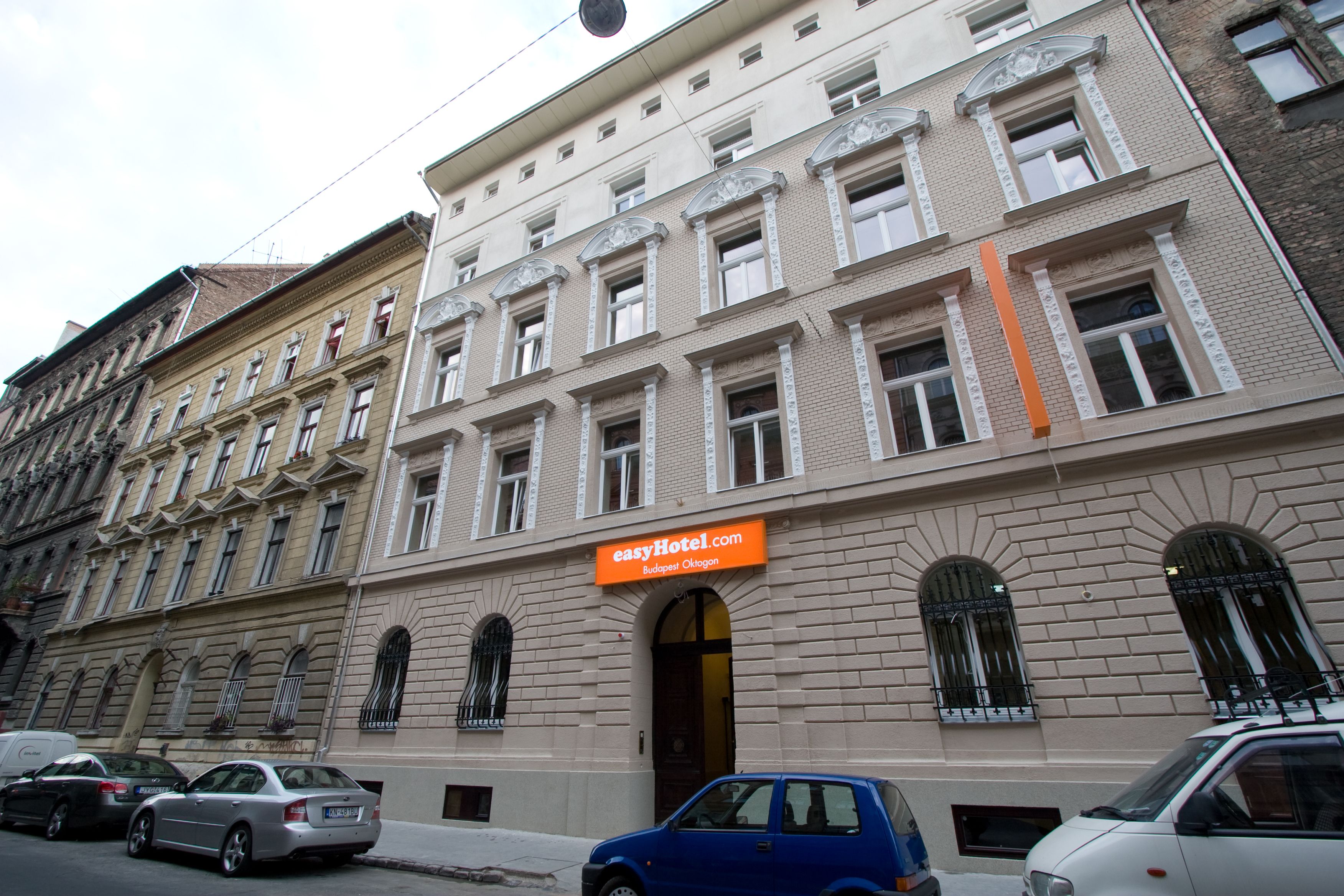 easyHotel Budapest Oktogon building exterior on a city street, showcasing its orange sign and classic architectural details.