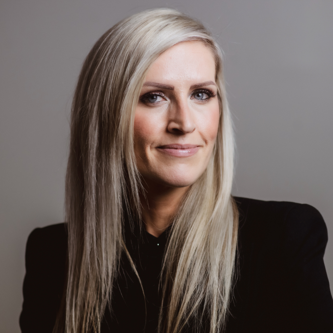 Professional headshot of a smiling woman with long blonde hair and blue eyes.