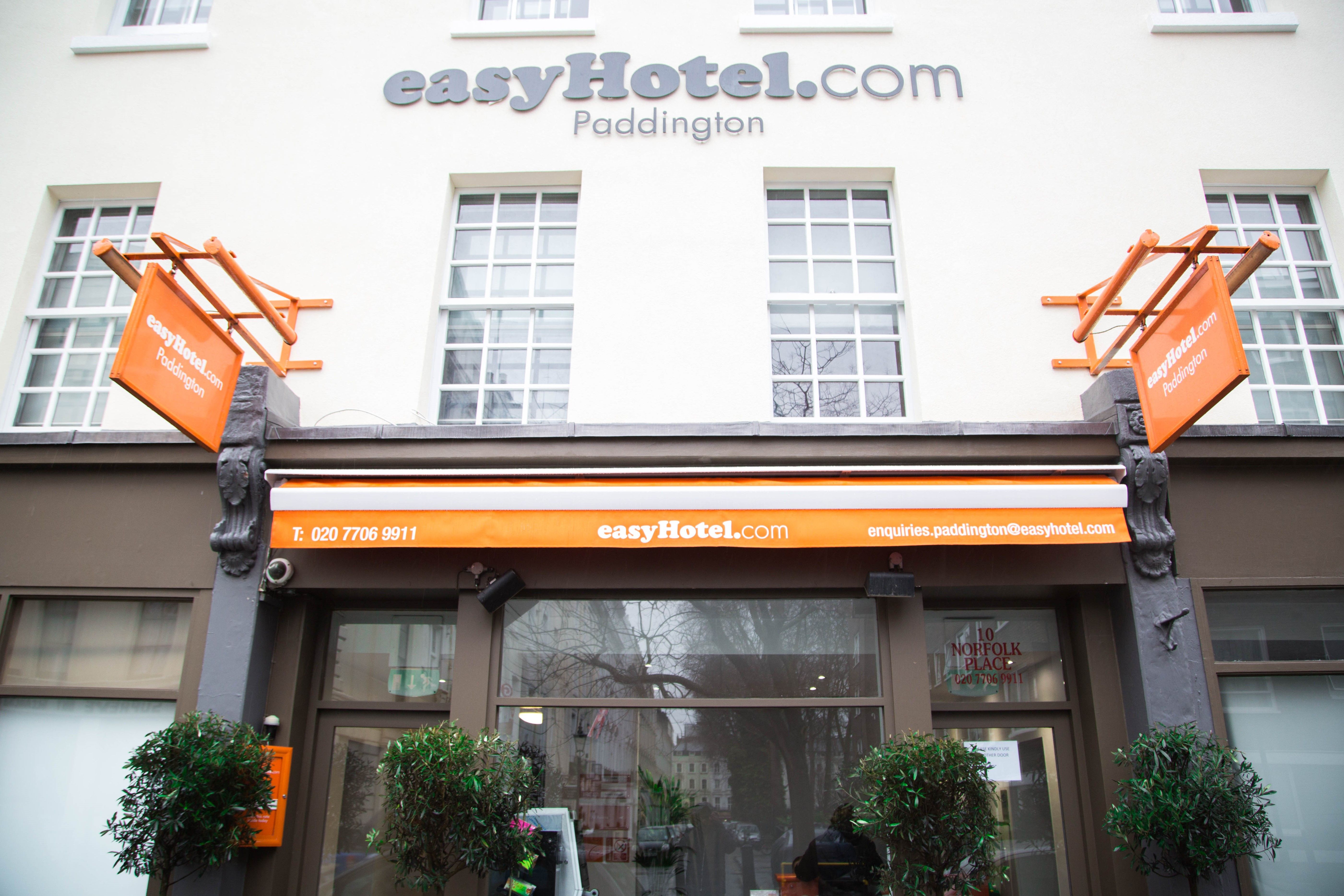 Exterior view of the easyHotel Paddington in London, showcasing its distinctive orange and grey branding on a white building facade with multiple windows.